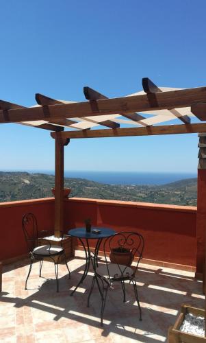 a patio with two chairs and a table on a roof at Antica Residenza Voso in Laureana Cilento