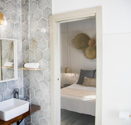 a bathroom with a bed and a sink and a mirror at Hotel Mariantonia in Chiclana de la Frontera