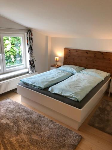 Schlafzimmer mit einem großen Bett mit einem Kopfteil aus Holz in der Unterkunft Apartment 5 in Wyk auf Föhr