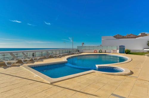 a swimming pool on top of a building next to the ocean at Carvoeiro Bay Apartment in Carvoeiro