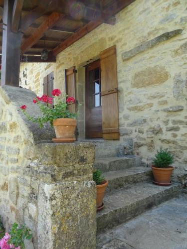 a stone house with potted plants on the stairs at La Terralha in Saint-Pierre-Toirac