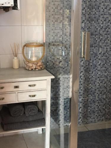 a bathroom with a white dresser and a shower at Wygodny murowany domek- NOWY in Dąbki