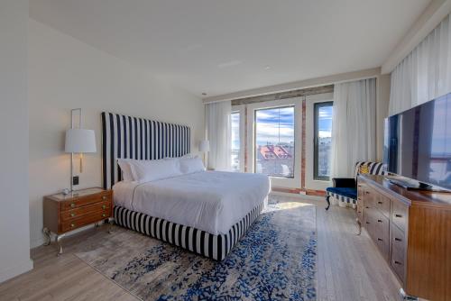 a bedroom with a bed and a flat screen tv at Monsieur Jean - Hôtel Particulier in Quebec City