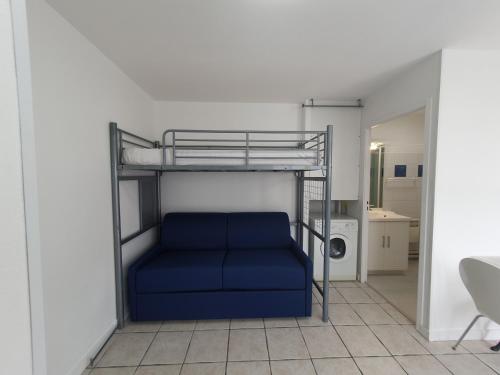 ラ・ロシェルにあるLe Cosy de Tasdonの二段ベッド1台(青いソファ付)が備わる客室です。