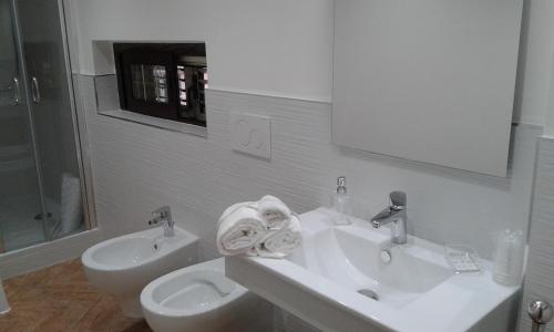 a white bathroom with a sink and a toilet at Lamezia Park Apartments in Lamezia Terme