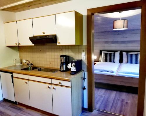 eine Küche mit einem Waschbecken und ein Bett in einem Zimmer in der Unterkunft Haus Vordertiefenbach in Wagrain