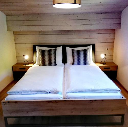 ein Schlafzimmer mit einem großen Bett und zwei Lampen auf beiden Seiten in der Unterkunft Haus Vordertiefenbach in Wagrain