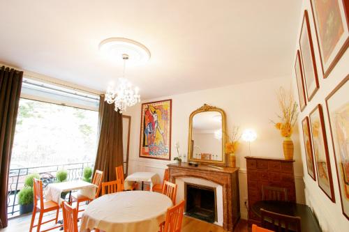 a dining room with a table and a fireplace at Hôtel Des Poètes avec parking sur réservation in Béziers
