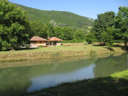 a house on the side of a river at Vodenica Lug in Strmosten