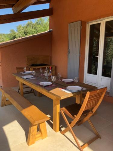 d'une table en bois avec deux chaises, une table et une chaise longue. dans l'établissement La Maison Bougnette, à Flassan