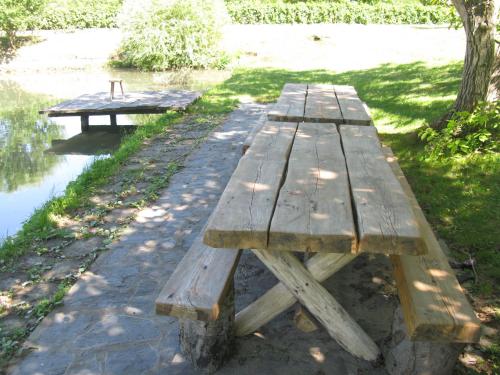 a wooden picnic table sitting next to a body of water at Vodenica Lug in Strmosten