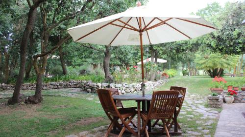 een tafel met een paraplu in de tuin bij Villa Misita in Prizzi