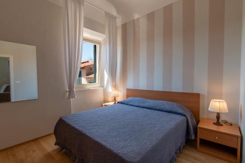 um quarto com uma cama azul e uma janela em CASA BICE em Rio nellʼElba