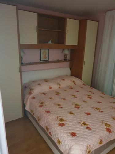 a bedroom with a bed with a floral bedspread at Apartments Martinović By The Sea in Kukljica