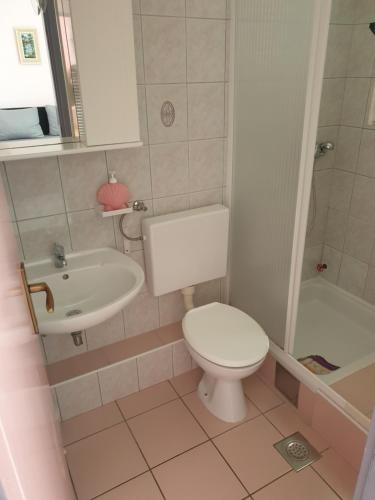a bathroom with a toilet and a sink at Apartments Martinović By The Sea in Kukljica