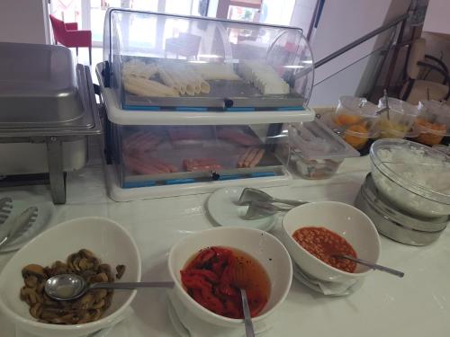 a kitchen counter with bowls of food in a refrigerator at Glyfada Beach Hotel in Glyfada