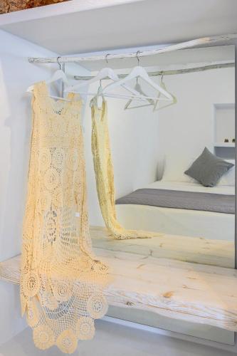 a bedroom with a bed and a dress on a shelf at Milinon Suites in Firopótamos