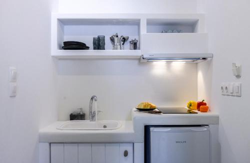 een kleine witte keuken met een wastafel en een wastafel bij Milinon Suites in Firopótamos
