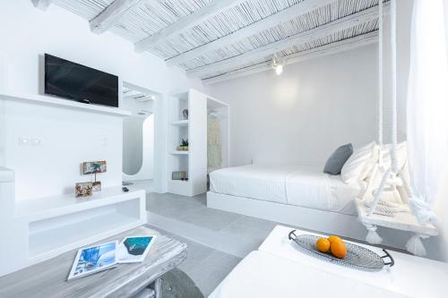 a white room with a bed and a table at Milinon Suites in Firopótamos