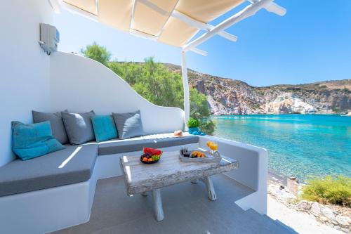 a living room with a couch and the water at Milinon Suites in Firopótamos