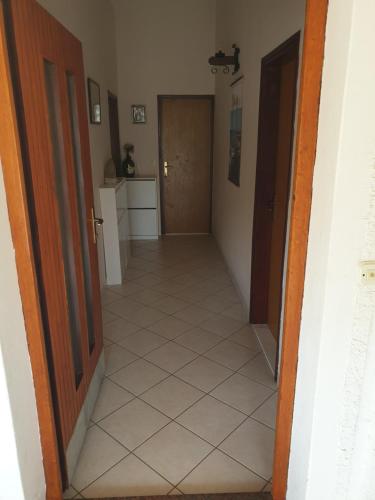 a hallway of a house with a door and a tile floor at Apartments Martinović By The Sea in Kukljica