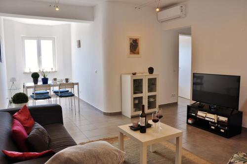 a living room with a couch and a tv at Casa Miguel in Carvoeiro