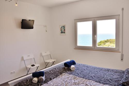 a bedroom with a bed and a television and a window at Casa Miguel in Carvoeiro