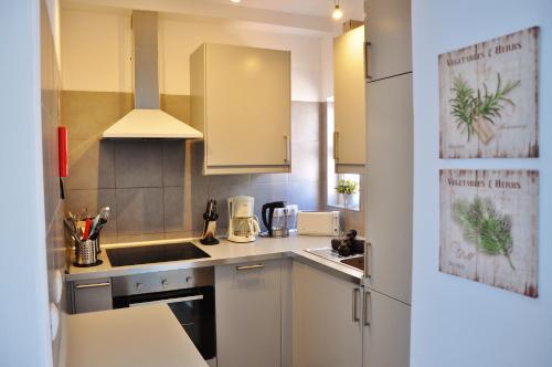 a small kitchen with white cabinets and a sink at Casa Miguel in Carvoeiro