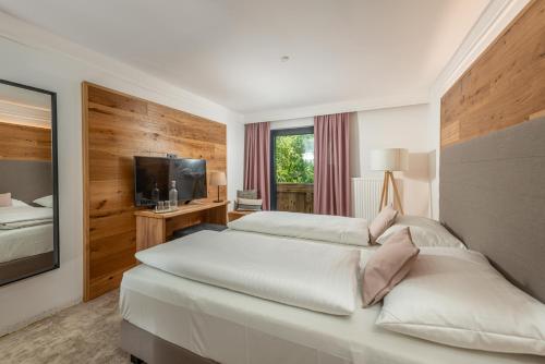 a hotel room with two beds and a television at Stadtvilla Schladming Boutiquehotel in Schladming