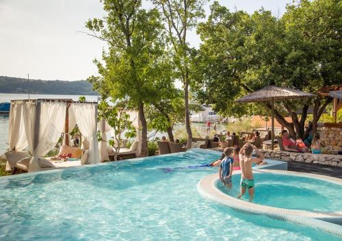 zwei Kinder spielen in einem Pool in einem Resort in der Unterkunft Fisherman's glamping village in Klimno