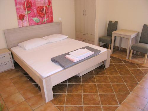 - une chambre avec un lit et 2 chaises dans l'établissement Apartment Damijan, à Krk