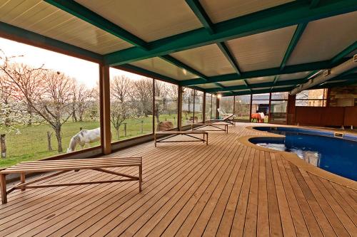 a deck with benches next to a swimming pool at Casa Cazoleiro in Meira