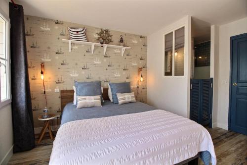 a bedroom with a large bed with blue and white sheets at La Cabine De La Baie in Saint-Pair-sur-Mer