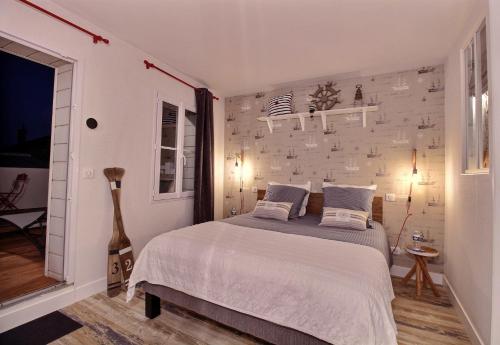 a bedroom with a bed and a brick wall at La Cabine De La Baie in Saint-Pair-sur-Mer