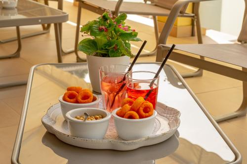 a tray with bowls of food and drinks on a table at Hotel Ascot in Cervia