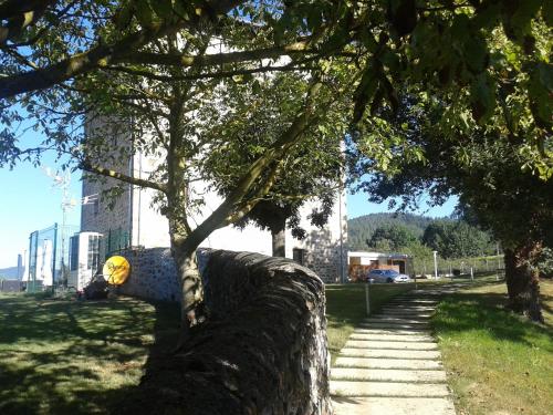 a stone wall with a tree next to a sidewalk at Hotel Torre Zumeltzegi in Oñate