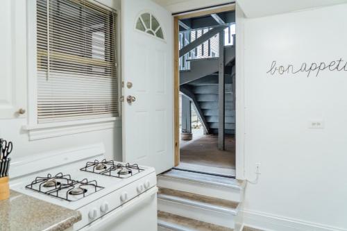 a white kitchen with a stove and a staircase at 1BR Modern Apt in the Heart of the City - Marshfield G in Chicago