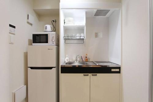 a small kitchen with a white refrigerator and a sink at Building A101 / Vacation STAY 1275 in Tokyo