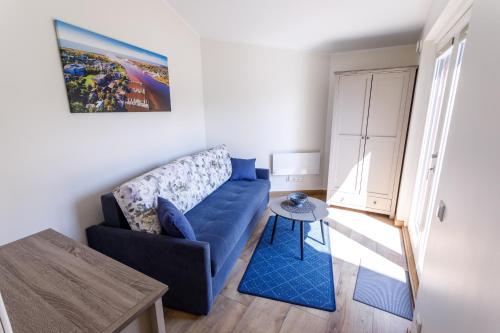 a living room with a blue couch and a table at Villa Rosalie in Pärnu