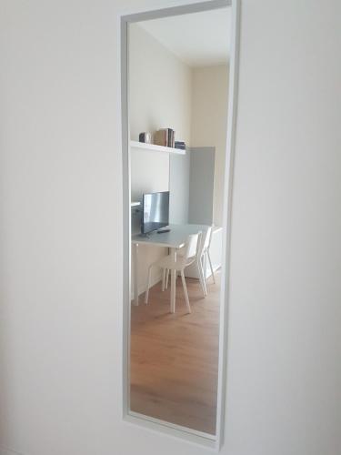 um espelho que reflecte uma sala de jantar com uma mesa em Affittacamere La Scala em Lecco