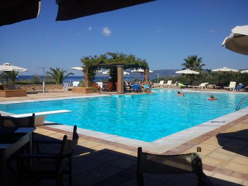 a large swimming pool with people in the water at Panselinos Hotel in Mithymna