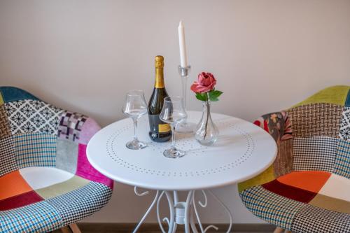 a white table with wine glasses and a rose on it at Old City Romantic Studios 3 in Pula