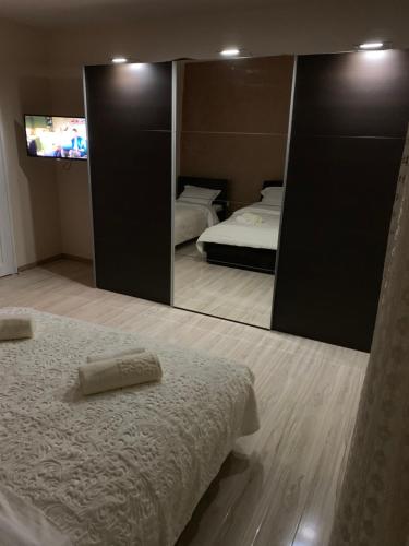 a bedroom with a mirror and a bed and a tv at Apartman Bedem in Nikšić