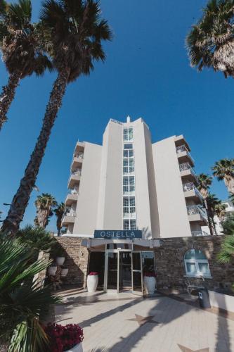 a building with palm trees in front of it at Ostella Spa & Resort in Bastia