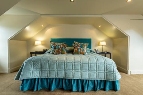 a bed with a blue comforter in a room at Isle of Eriska Hotel Spa & Island in Benderloch