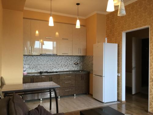 una cucina con un frigorifero bianco e un tavolo di Welcome генацвале))) a Tbilisi City