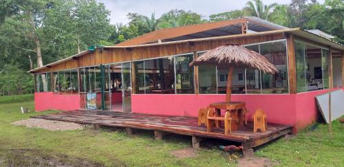 a pink house with a table and chairs in front of it at Estância Cyclo das Águas in Nobres