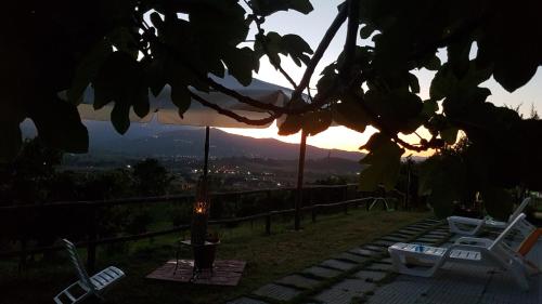 a view of a sunset from a backyard with a chair and an umbrella at Zefiro Casa Vacanze in Ascea
