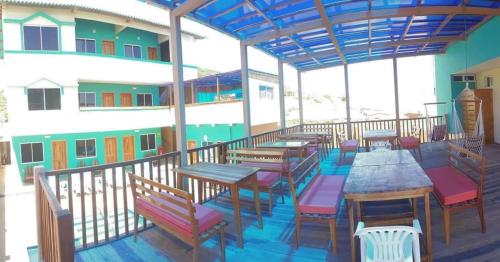 a restaurant with tables and chairs on a balcony at The Lookout Beach Hotel in San Lorenzo