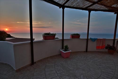 a balcony with a view of the ocean at sunset at Il Cigno Affittacamere Bed & Breakfast in Ponza